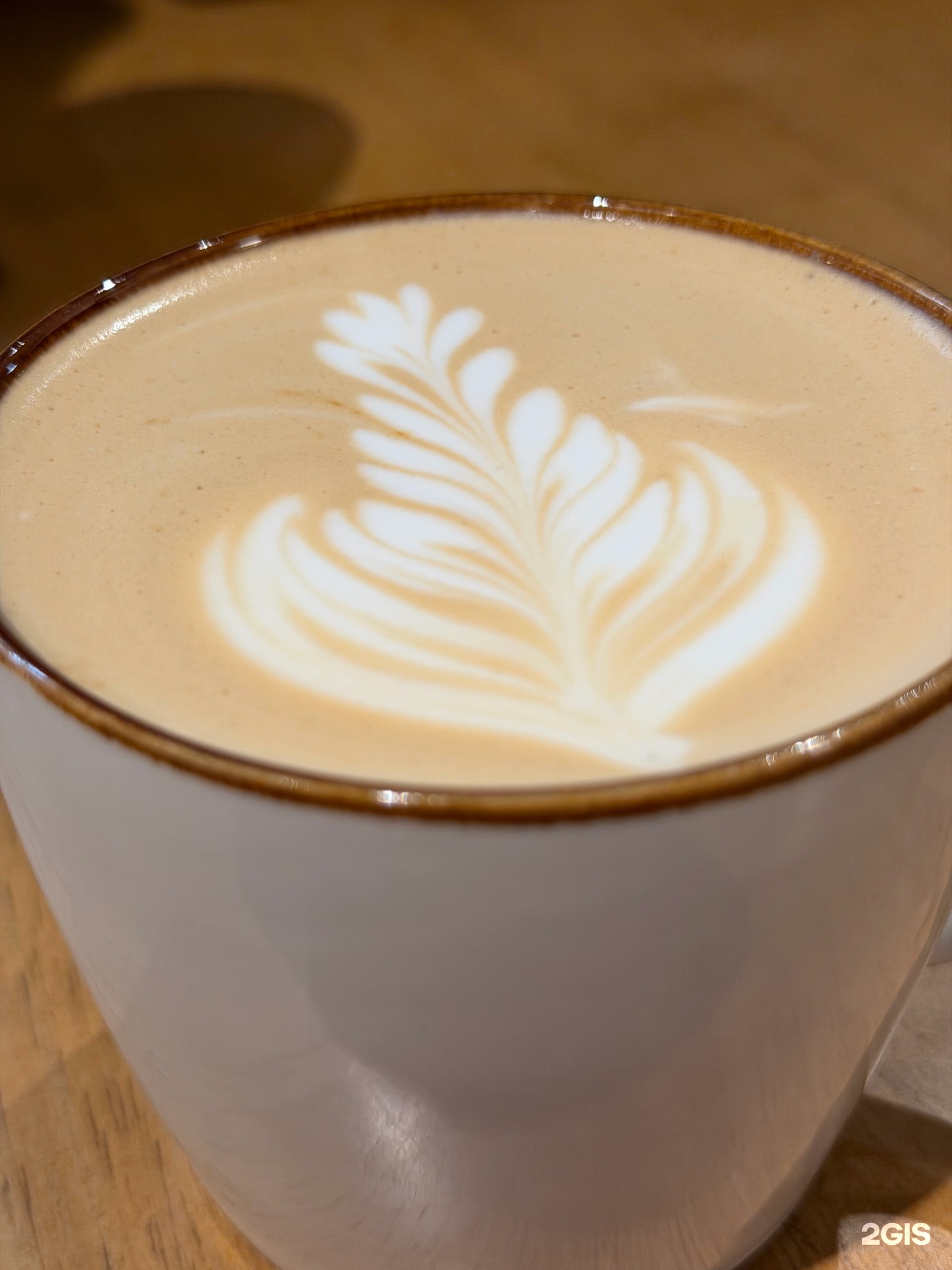 Чашка кофе с молоком и рисунком на пене в Barista Coffee